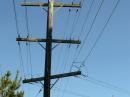 The south lead H-frame was severely damaged when a large tree branch fell on it, and about half of the feed lines are not usable. It will be rebuilt later. This photo shows one of the farther out poles. Line spacers now have been added and the line “dress” adjusted for maximum clearance of cross-arms. The wire is #4 solid copper.